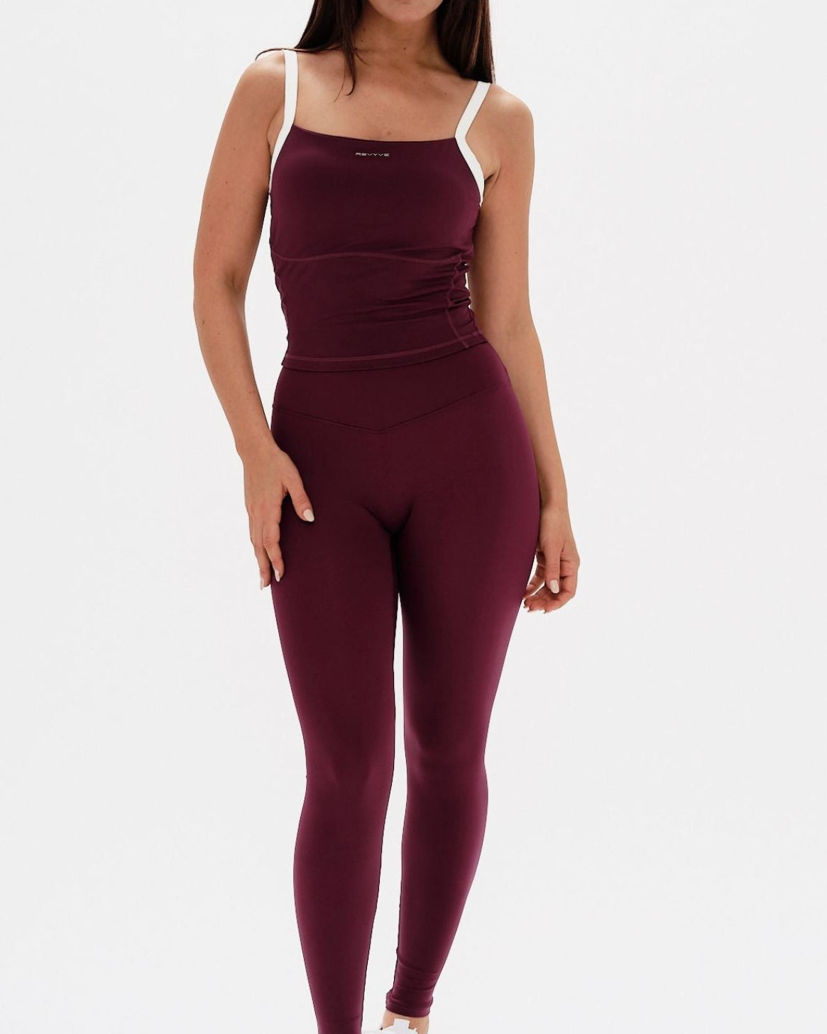 Woman wearing a burgundy athletic outfit on a white background